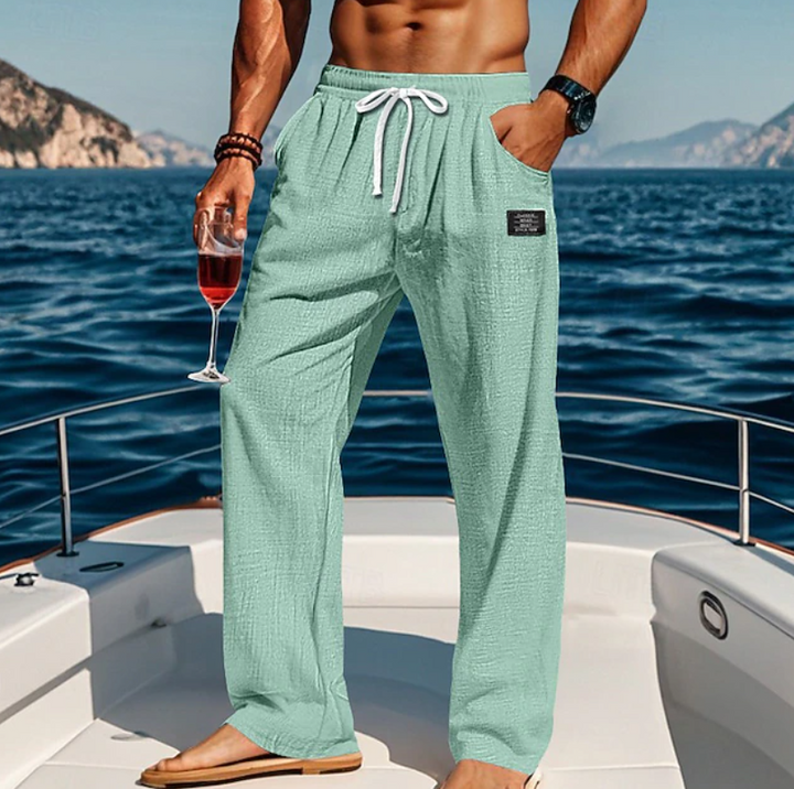 Man wearing loose, breathable casual summer trousers with lace waist. Ideal for beach, vacation, or relaxed daily wear.