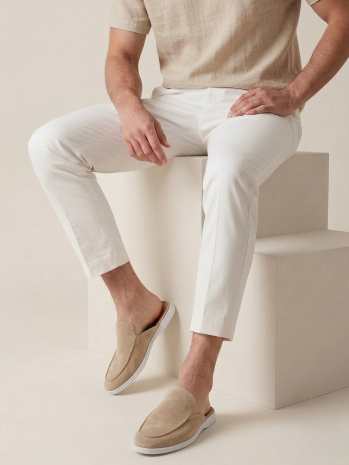 Full pair of men's comfortable casual mules with open heels and refined stitched details. Slip-on style.