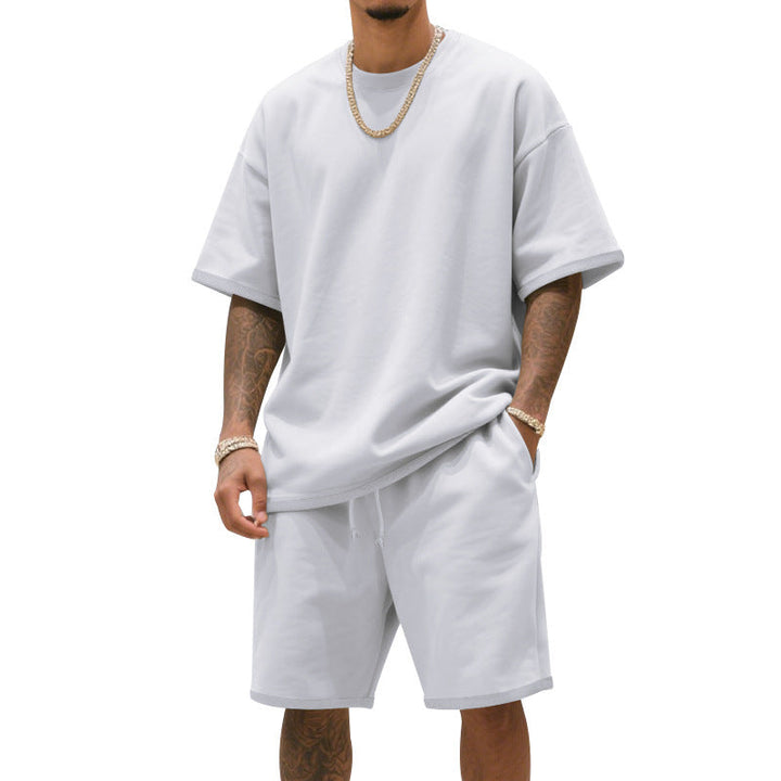 Full shot of a man wearing a sporty t-shirt and shorts combo, suitable for fitness and relaxation.