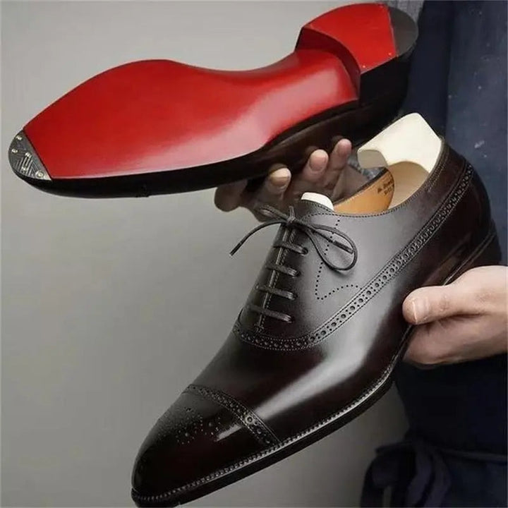Elegant men's brown brogue oxford dress shoes with intricate detailing and classic lace-up design.