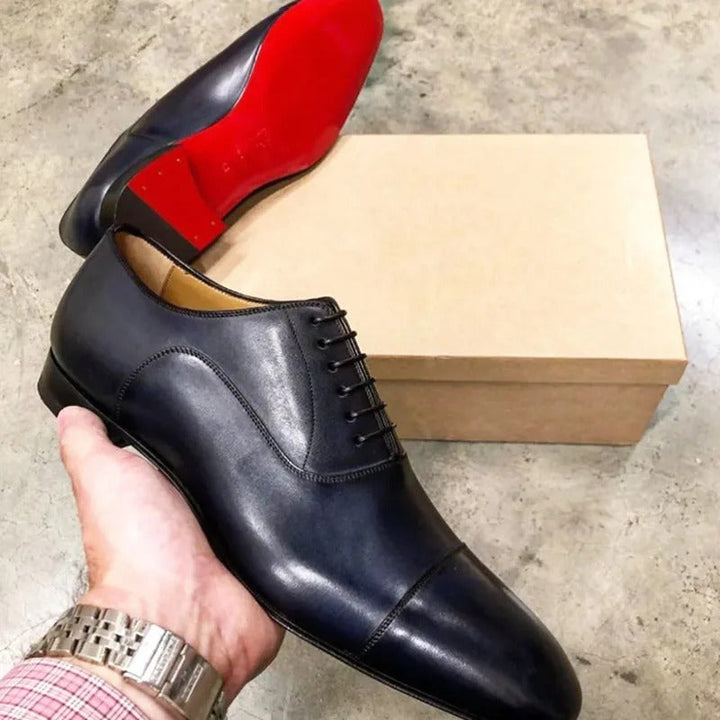 Men's classic black Oxford dress shoes with sophisticated lace-up design and signature red sole for formal occasions.