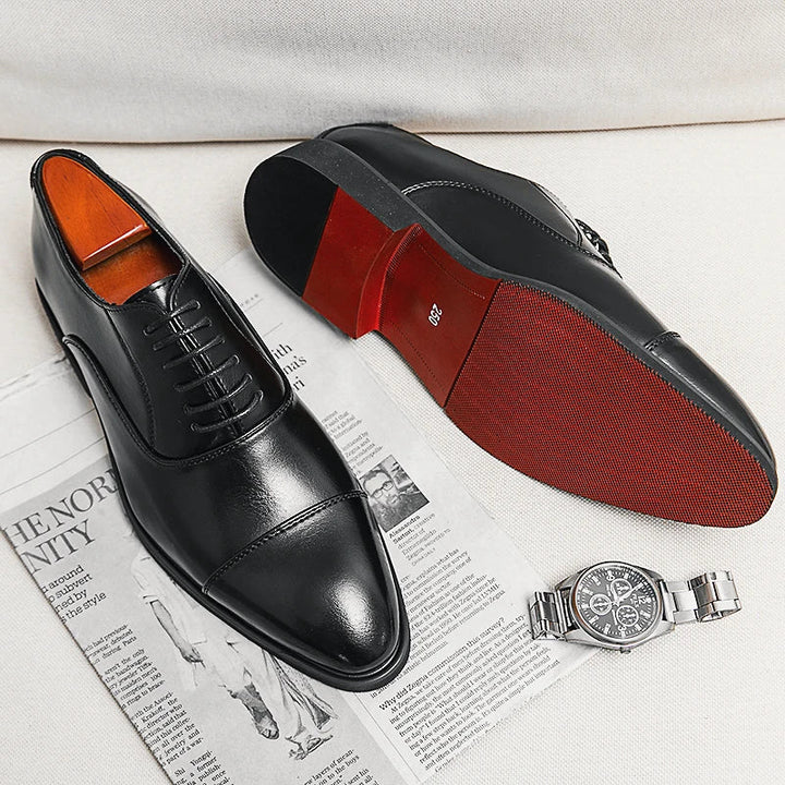 Stylish men's leather Oxford dress shoes with intricate detailing, classic lace-up style, and iconic red sole.