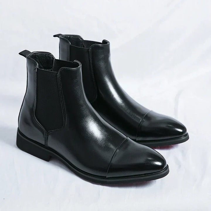 Sleek black leather men's cap toe Chelsea ankle boots, comfortable pull-on design for modern fashion.