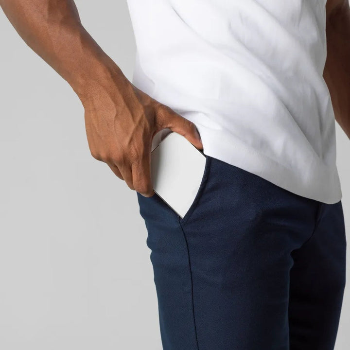 Detail of waistband and pockets on men's chino pants, emphasizing functional and stylish menswear. Flat front design.