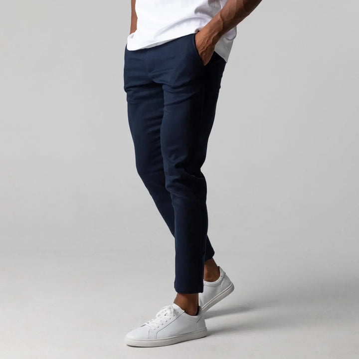 Man in stylish blue chino pants with a blazer, showcasing a smart casual, versatile men's outfit. Elegant fashion.