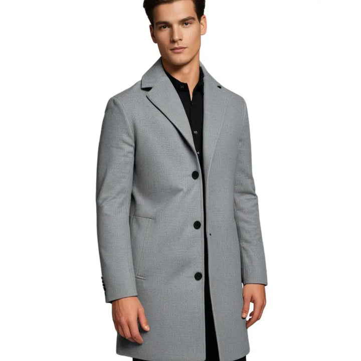 Man in a classic tailored long overcoat. Demonstrating smart casual men's winter fashion and layering.