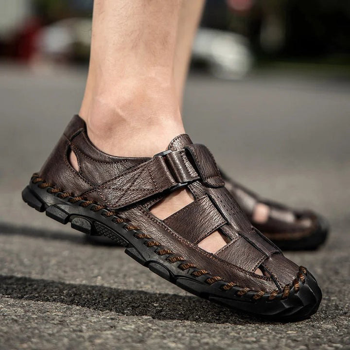 Two pairs of men's closed-toe leather fisherman sandals (brown & black) with hook-loop for summer comfort.