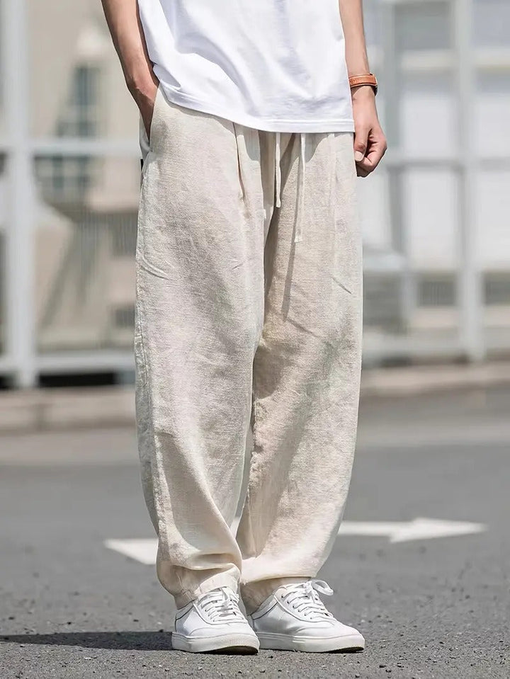 Men's cream wide leg linen blend trousers with a relaxed drawstring fit, perfect for casual summer style and comfort.
