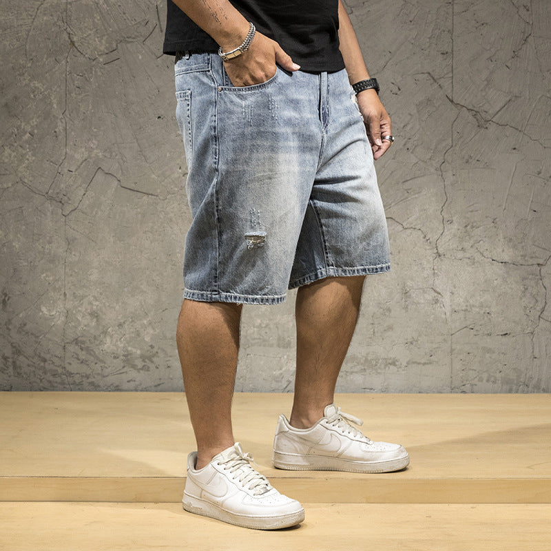 Light wash distressed denim shorts for men, featuring stylish rips, great for a modern street style look.