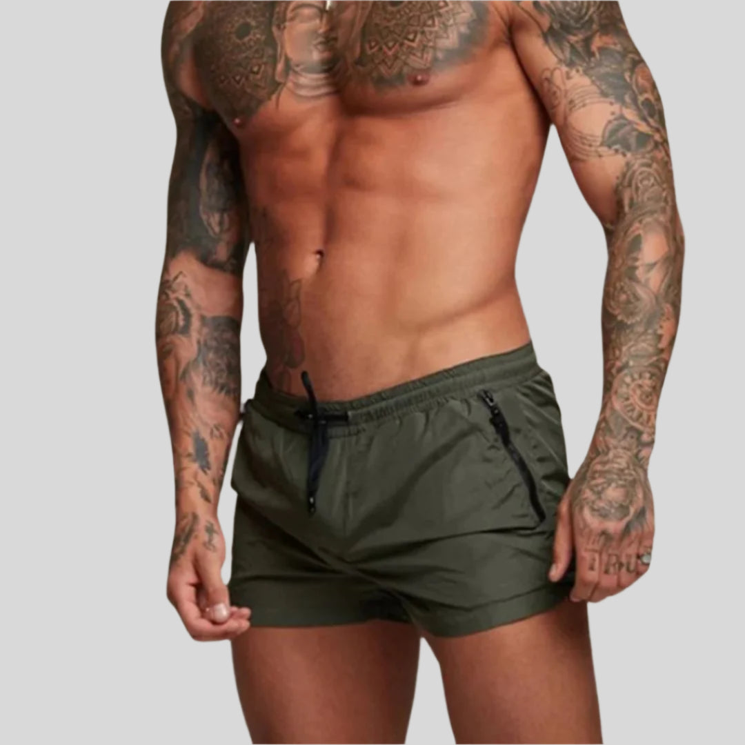 Quick-dry fabric men's swim shorts, perfect for active resort wear. Features drawstring & zip pocket.