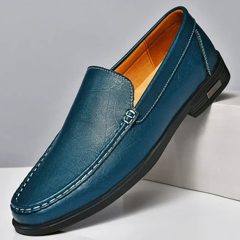 Men's elegant black slip-on loafers paired with a suit, illustrating versatile formal and business casual men's fashion style.