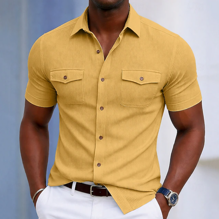 Detail shot of a men's button-up shirt's chest pocket and front buttons. Highlights quality for everyday wear.