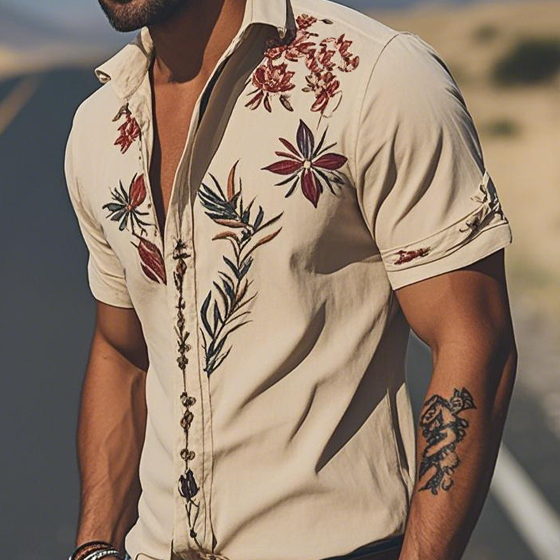 Close-up of intricate floral embroidery on a men's short sleeve casual button-up shirt.