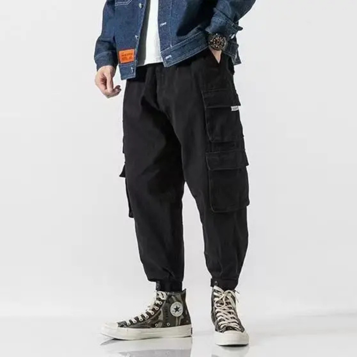 Green men's streetwear cargo pants with adjustable waist, combining style & practical utility.