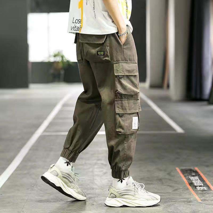 Green men's tapered cargo pants with utility pockets, perfect for streetwear and casual fashion.