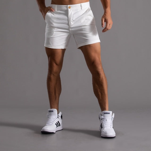 Model wearing men's knee-length chino shorts, demonstrating movement and summer casual style.