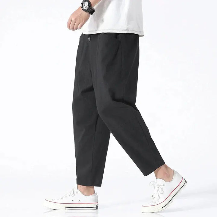 Stylish men's cropped tapered pants paired casually, showcasing modern fit, relaxed comfort, and versatile design.