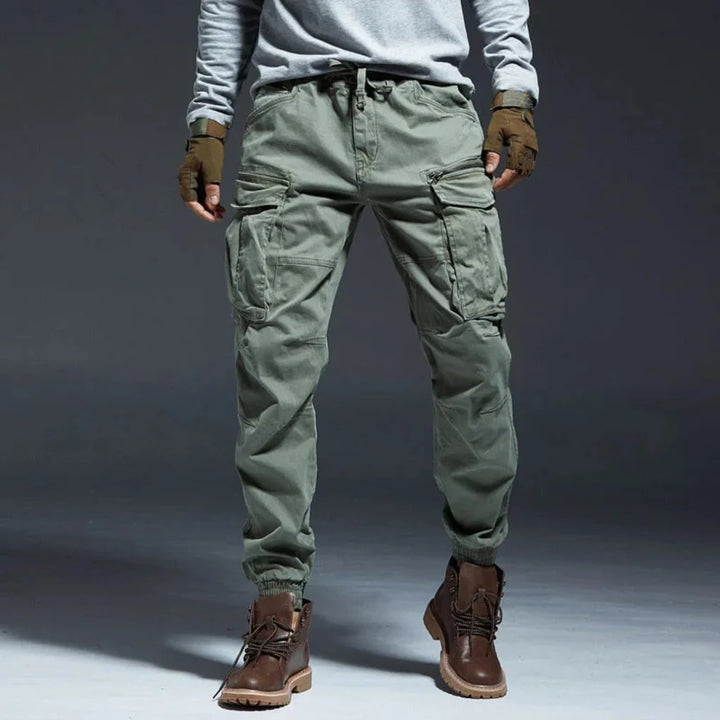 Utility men's cargo pants with an elastic waist & ample pockets, perfect for travel & ultimate comfort.