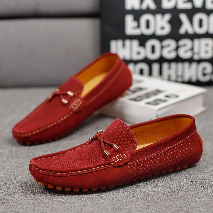 Men's gray perforated slip-on loafers with bow detail, perfect for smart casual summer footwear.