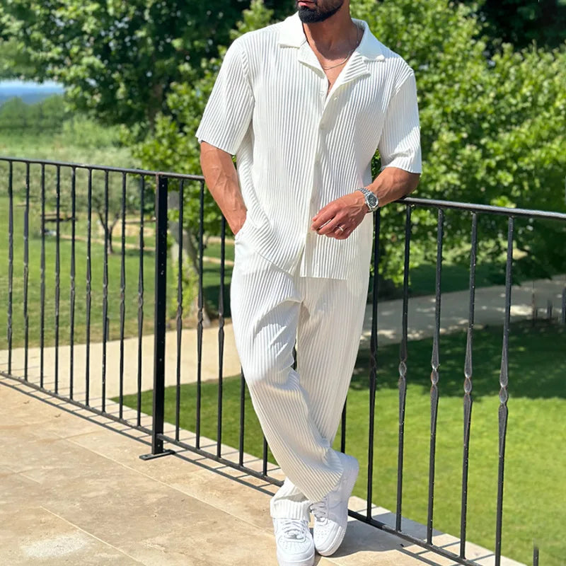 Men's pleated two-piece set with short sleeve camp collar shirt & straight leg trousers, ideal for summer holidays.