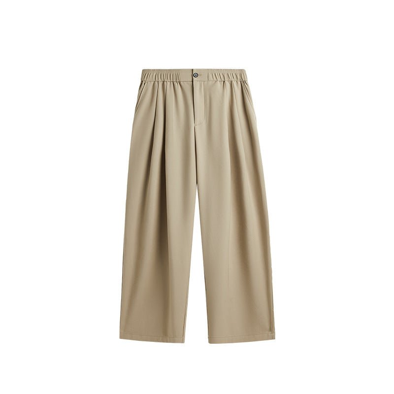 Full-length view of men's comfortable wide leg drawstring trousers with pleats in a relaxed pose.