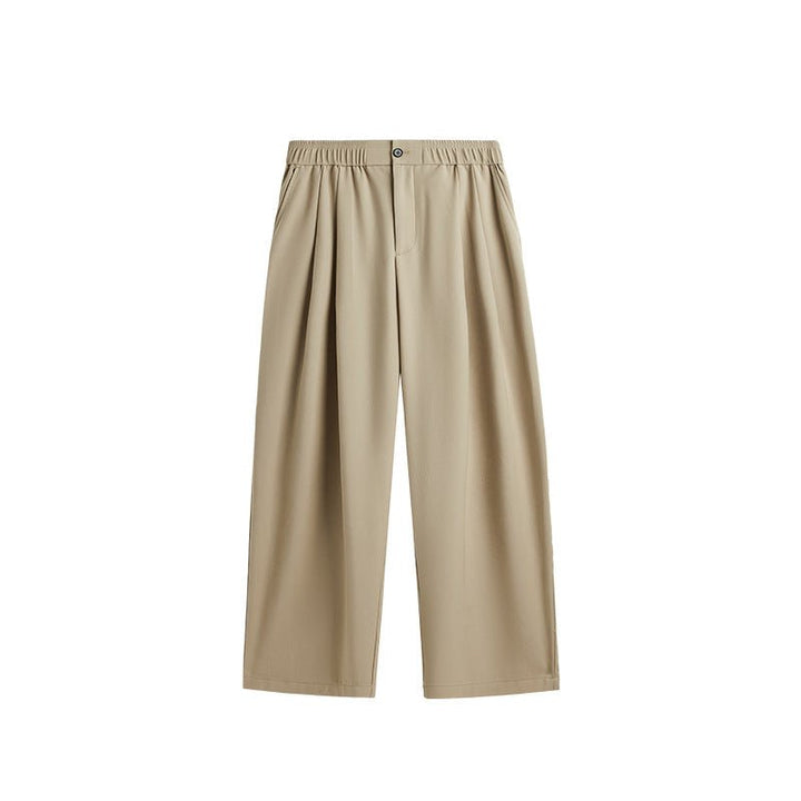 Full-length view of men's comfortable wide leg drawstring trousers with pleats in a relaxed pose.