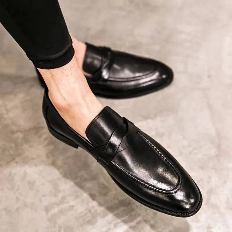 Close-up of men's polished leather penny loafers with classic strap detail. Smart casual to formal work footwear.