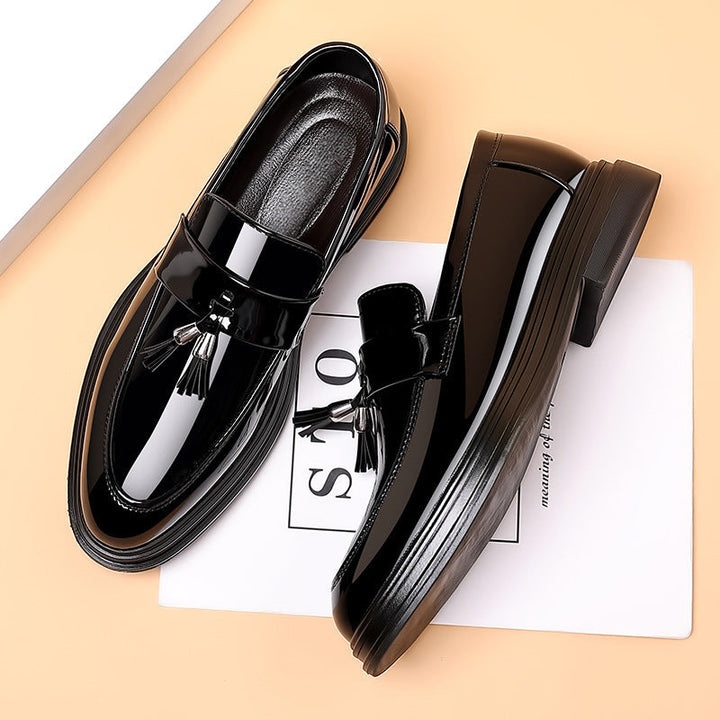 Classic men's slip-on polished black leather tassel loafers, perfect for business and special events.
