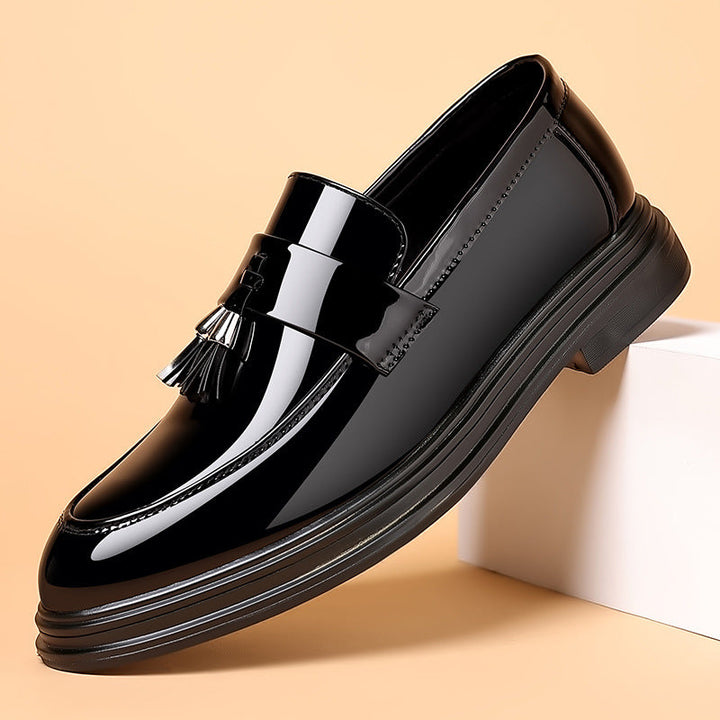 High-shine men's polished black leather tassel penny loafers, essential formal & smart casual footwear.