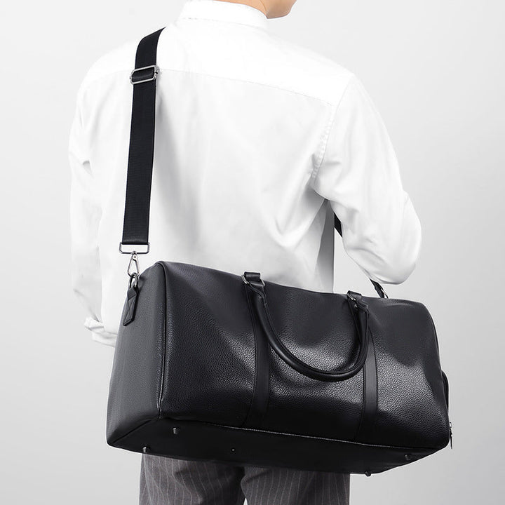 Spacious black leather carry-on duffle bag for men, perfect for weekend getaways & business travel.