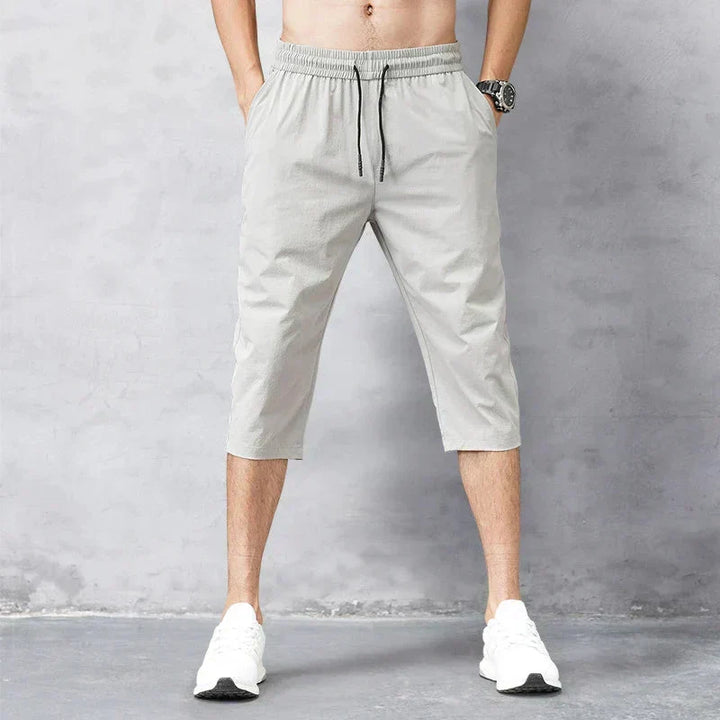Close-up of men's quick-dry fabric long swim shorts, ideal for athletic beachwear, pool, and water sports. Summer activewear.