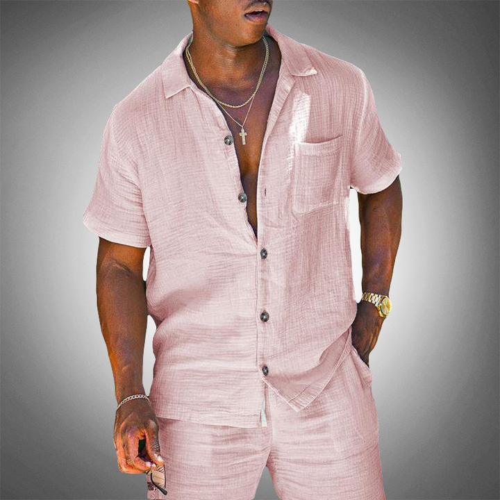 Comfortable men's pink two-piece outfit with relaxed shirt & matching trousers for a modern summer look.