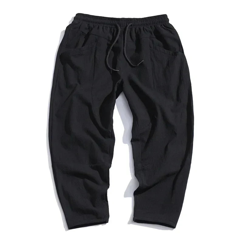 Close-up of men's cropped drawstring trousers. Lightweight fabric detail, perfect for casual summer outfits.