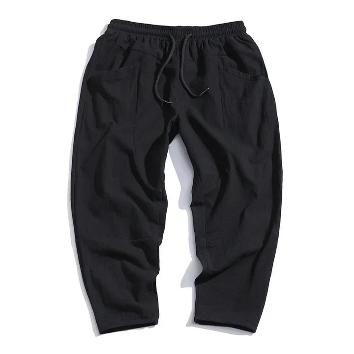 Close-up of men's cropped drawstring trousers. Lightweight fabric detail, perfect for casual summer outfits.