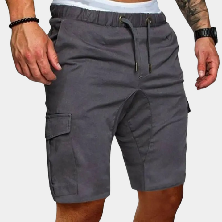 Man wearing versatile relaxed fit men's drawstring cargo shorts for comfortable summer outdoor activities.