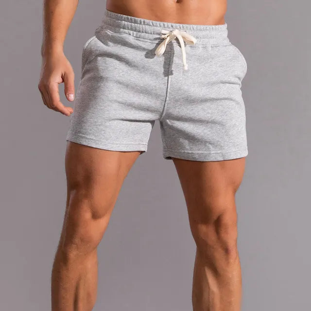 Man wearing relaxed fit drawstring jogger shorts, perfect for summer activities, athletic comfort, & casual style.