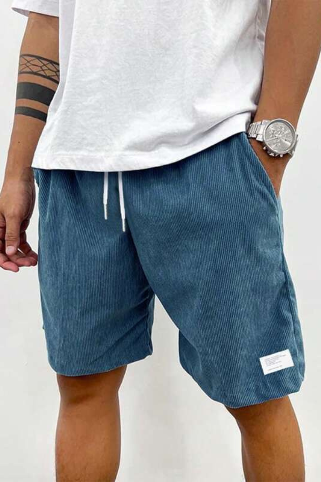 Stack of men's relaxed fit drawstring shorts in various colors, versatile for summer casual wardrobes.