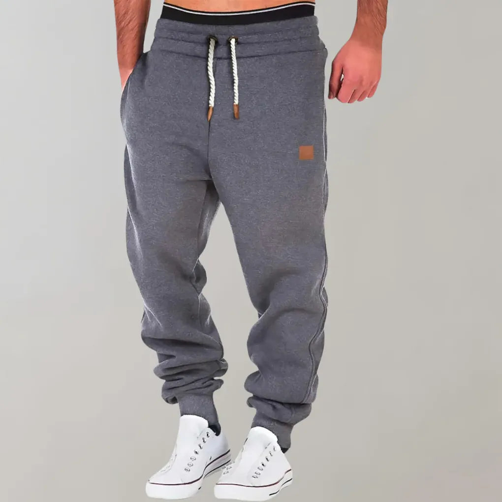 Soft men's relaxed fit track jogger pants in grey, offering comfort for lounging or light activity.