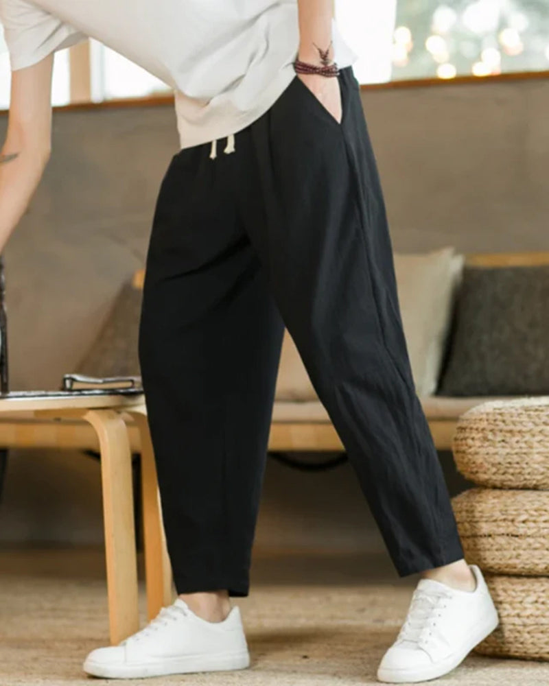 Close-up of men's casual cotton drawstring trousers, showcasing comfortable elastic waist and relaxed fit.