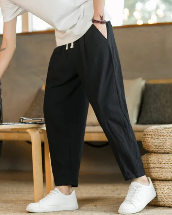 Close-up of men's casual cotton drawstring trousers, showcasing comfortable elastic waist and relaxed fit.