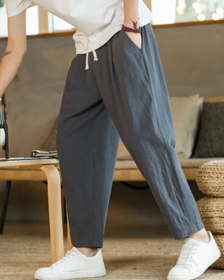 Man modeling comfortable relaxed fit cotton drawstring trousers, ideal for versatile casual men's fashion.