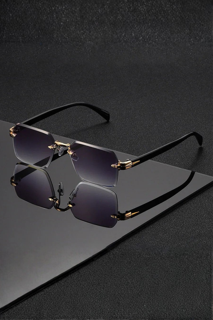 Sleek rimless men's sunglasses with a distinctive gold bridge and gradient tinted lenses. Modern eyewear design.