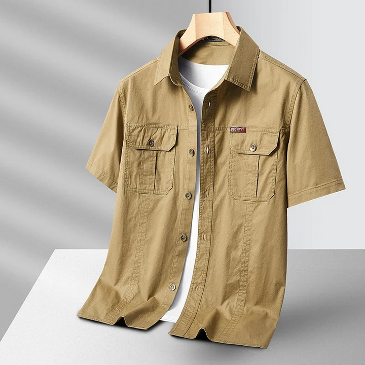 Breathable men's short sleeve button-up utility shirt in olive, ideal for summer travel, casual wear, and outdoor activities.