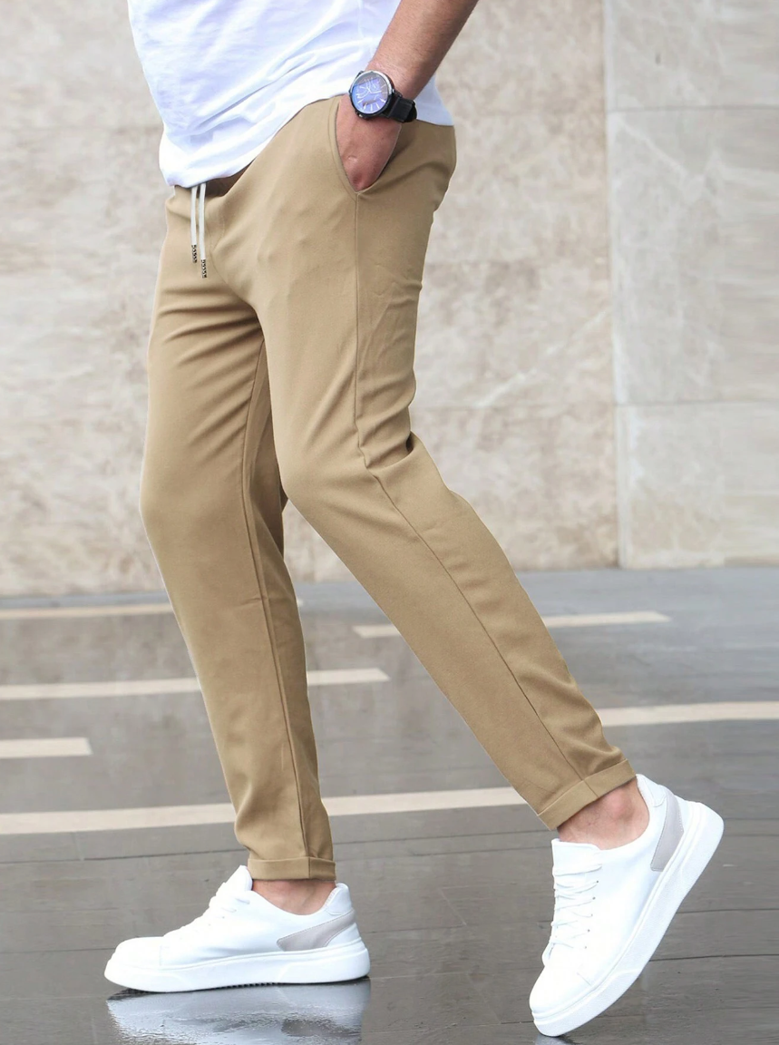 Full shot of men's dark slim fit drawstring trousers, showcasing their modern tapered design.