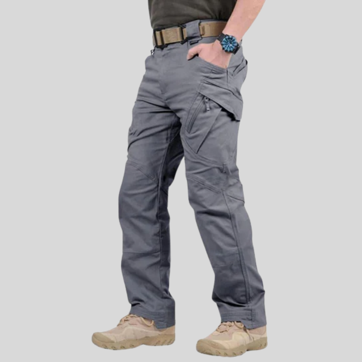 Close-up of men's multi-pocket stretch cargo pants in navy, showing durable stitching & relaxed fit.