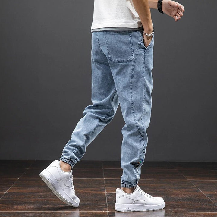 Comfort-fit men's denim joggers, stretch cotton blend fabric, elastic waist for easy wear.