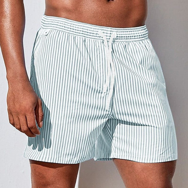 Close-up of men's striped swimwear shorts, showing drawstring detail and quick-dry fabric texture for summer.