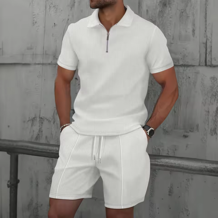 Man wearing a sleek men's co-ord set: short-sleeve polo shirt & drawstring shorts, ideal for summer.