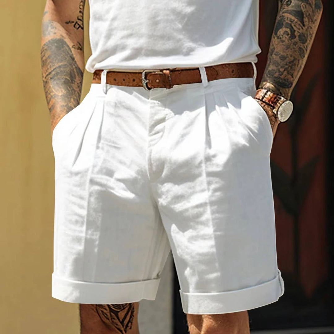 White men's tailored pleated summer shorts, refined fit, turn up hem. Smart casual fashion for hot weather.