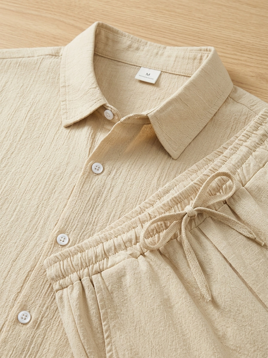 Stylish men's two-piece outfit set: textured short sleeve shirt & comfy drawstring trousers. Versatile casual wear.